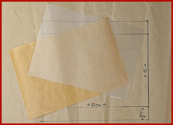 Laminierfolie und Backpapier liegen auf einem Stück Packpapier