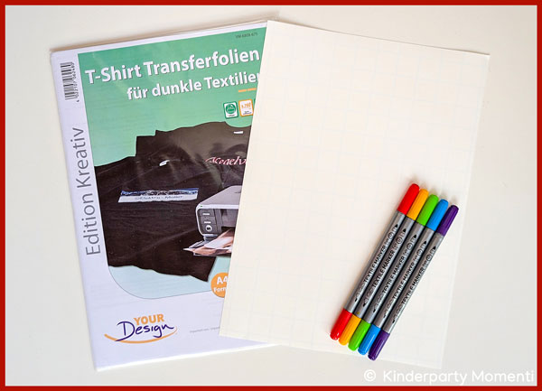 Eine Verpackung mit Transferfolie für T-Shirts und daneben vier bunte Textilmarker